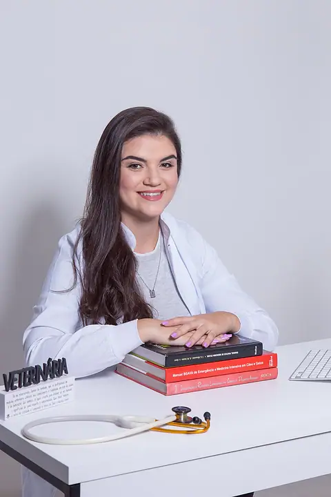 Dra. Kathy Alves com livros de medicina veterinária e estetoscópio
