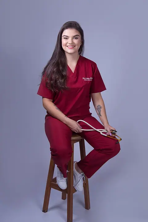 Dra. Kathy Alves sentada, com o estetoscópio na mão
